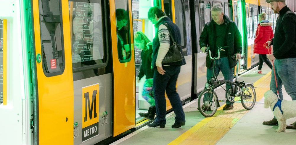 A Metro customer takes a folding bike on a train